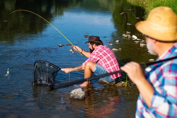 渔夫的朋友和奖杯鳟鱼 父亲和儿子钓鱼 几代人在河里钓鱼 — 图库照片