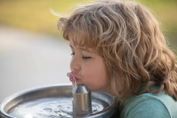 屋外の噴水屋外から子供が水を飲む のどが渇いた子 ロイヤリティフリーのストック写真