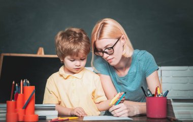 Okula ve mutlu zamanlara. Öğretmen ve çocuk. Öğretmenler okulda çocukların ödevlerine yardım ediyor. Okul ve çocuk konsepti