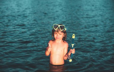 Çocuk yaz tatilinde plajda yüzer. Doğada güzel denizleri olan bir çocuk. Suda yüzen mutlu çocuklar