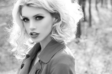 Açık havada güneşli bir günün tadını çıkaran güzel ve genç bir kadının yakın portresi. Bahar makyajı.