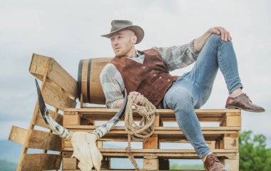 Şapkalı bir kovboy. Batı hayatı. Yakışıklı sakallı batı çiftçisi. Kovboy ya da çiftçi portresi. Batı. Erkekler eski moda, eski moda, vahşi erkek model.