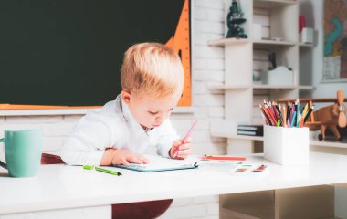 Sınıfta öğretmenlik okuyan şirin bir anaokulu çocuğu. Öğrenme ve eğitim kavramı. Öğrenciler için ev okulu. 3 yaşında bir çocuk.