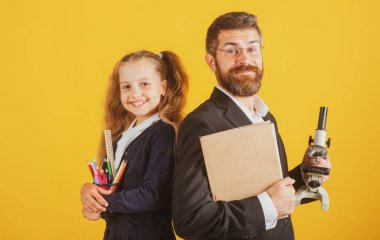 Stüdyoda öğretmeni olan ilkokul öğrencisi, izole edilmiş. Mutlu liseli kızla öğretmen. Komik okul kızı portresi ve okul malzemeleriyle özel öğretmen.