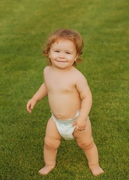 緑の芝生のフィールドで遊んでおむつで面白い赤ちゃん 夏の屋外の子供のライフスタイル — ストック写真