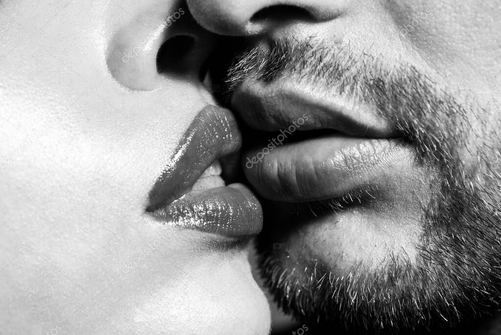 Close-up of young romantic couple is kissing each other. Red lips and sensual open mouth. Sexy kiss