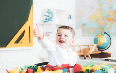 Heyecanlı okul çocuğu başparmağını kaldırdı. Anaokulundaki ilkokul öğrencileri