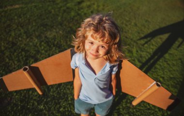 Oyuncak jetpack ile oynayan komik çocuk. Çocuk pilot astronot ya da uzay adamı uçmayı hayal eder. Karton kanatlarla uçan havacı çocuk.