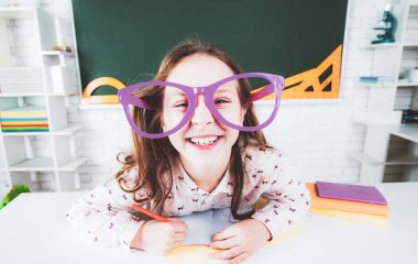Sınıfta gözlüklü komik bir öğrenci. Çalışmaya biraz hazır. Okula dönelim. Okuldaki öğrenciler, çocuk eğitimi.