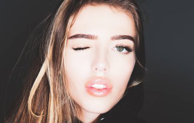 Komik kız suratı, yakın çekim. Göz Kırpan Kadın. Güzel moda portresi. Gülümseyen genç kadın göz kırp