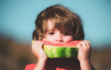 Mutlu çocuk karpuz yiyor. Doğada sağlıklı karpuz yiyen tatlı çocuk. Taze organik karpuzlar