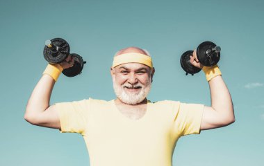 Dambılı kameraya bakan mutlu son sınıf öğrencisi. Vücut bakımı ve sağlık hizmetleri. Büyükbaba sporcu portresi mavi arka planda