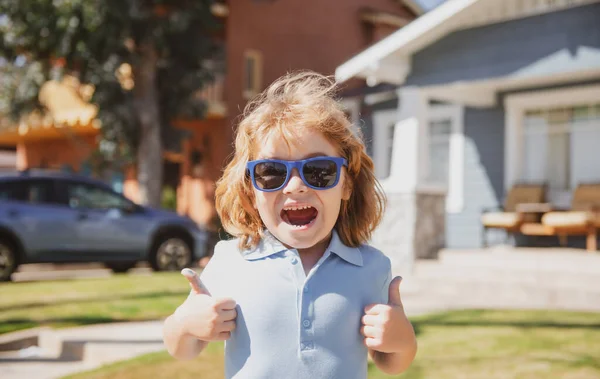 興奮した子供たちは 親指をサインアップしてサングラスで肖像画 家の近くにかわいい子供の屋外の家の近くの頭を閉じます 驚くべき興奮した子供の感情 — ストック写真