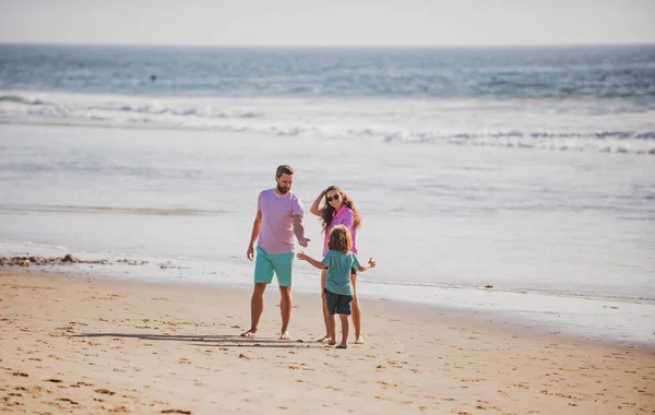 父の母親と息子のビーチの夕日を歩く 海での家族 — ストック写真