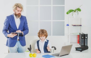 Ofisteki bir iş masasında patronluk taslayan küçük çocuk. İşadamı ekibi yeni bir proje için ofiste çalışıyor. Takım işi. İş ekibi beyin fırtınası yapıyor.