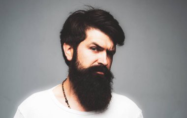 Kendine güvenen ciddi bir adamın portresinin sakalı ve bıyığı var. İş adamı kendini ifade ederek düşünür. Yakışıklı erkek model, yakın çekim yüzü.