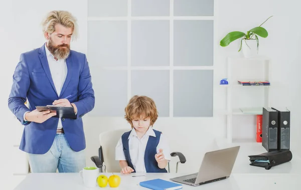 オフィスのビジネス机の上で上司になるために遊んでいる小さな男の子 ビジネスマンはオフィスで新しいスタートアッププロジェクトに取り組んでいます チームの仕事だ ビジネスチームのブレインストーミング — ストック写真