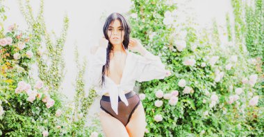 Bahar güneşli portre. Gül bahçesindeki seksi bahar kadını. Açık havada şehvetli bir kız. Doğal güzellik. Bahar geldi.