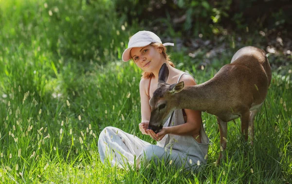 女は鹿に餌をやる 自然との統一 野生動物の概念 女の子はバンビを養う 公園の動物 — ストック写真