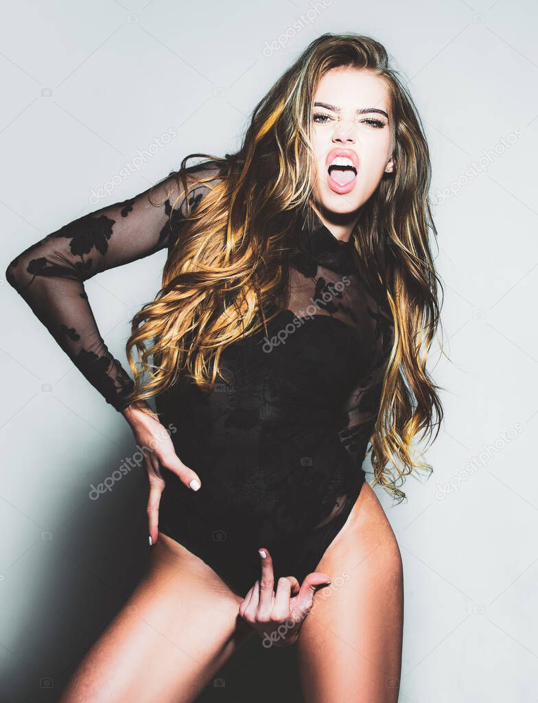Woman in erotic underwear. Finger that says fuck. Fuck you hand gesture. Passion and temptation. Perfect female body in sexy lingerie. Fuck you off sign between her legs