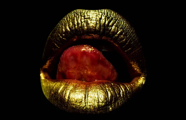 Golden mouth. Sexy gold lips, golden art. Isolated woman golden mouth with tongue out. Isolated on black background, clipping path