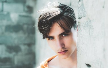 Gri duvara karşı şık bir genç adam.