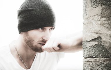 Gri arka plandaki yakışıklı genç adam kameraya bakıyor. Yakışıklı bir adamın portresi, arka planı gri ve fotokopi alanı var.