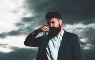 İçki konsepti, yakışıklı sakallı adam pahalı içecekler içiyor.