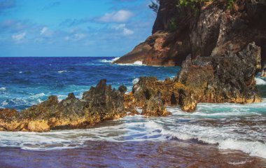 Taşlı deniz kıyısı, okyanus manzaralı. Vahşi taş sahilindeki kayaların üzerinde deniz dalgaları. Tropikal deniz rahatla
