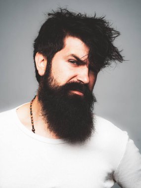 Stüdyodaki hippi adam modelleri. Yakışıklı bir erkek model, yakın çekim yüzü. Berber dükkanında uzun sakallı ve bıyıklı bir berber. Sakallı adam.