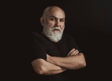 Siyah arka planda olgun bir adamın portresi. Ciddi kıdemli adam.
