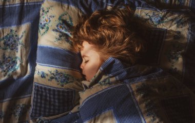 Evdeki yatakta uyuyan sevimli çocuklar. Sessiz bir uyku. Rahat çocuklar sabahları uykulu olurlar.