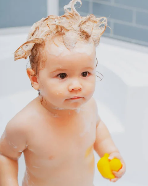有趣的金发男孩在浴缸里洗澡 在浴室里洗可爱的小宝宝洗头时 孩子身上有肥皂 儿童保健和卫生 — 图库照片