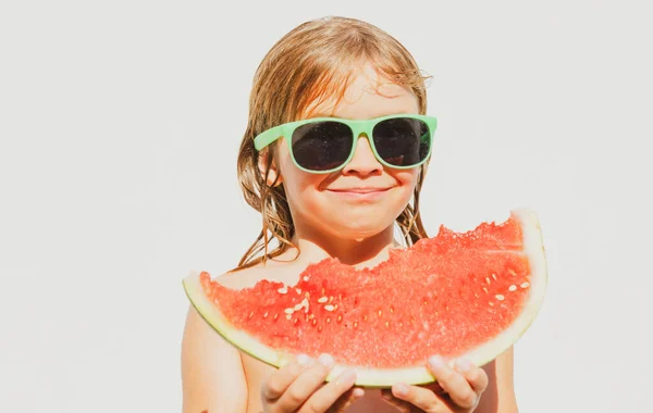Child boy eats watermelon near the pool. Kid with water melon, isolated on white. Kids summer activities
