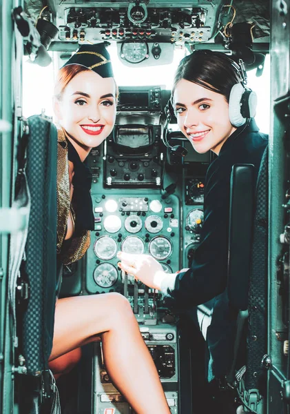 Couple Smiling female pilots in the aircraft. Portrait of smiling female pilots. Looking at camera in plane. Portrait of attractive woman trainee pilot with headset preparing to fly