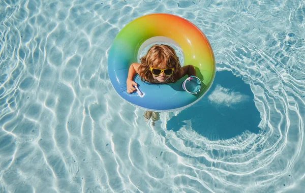 Kid in summer pool. Activities on pool. Child swimming in water. Summertime vacation