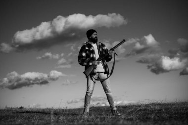 Silah tutan ve ormanda yürüyüş sakallı avcı adam. Hunter avı av tüfeği silah ile