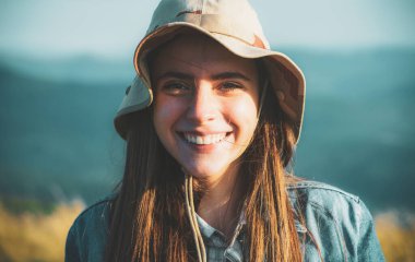 Beslenme sırasında gülümseyen ve parka bakan güzel bir kadının portresi. Gülümseyen bir kızın açık hava portresi. Mutlu neşeli kız parka gülüyor.