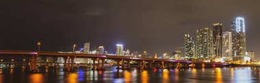 Miami Florida, günbatımı manzarası renkli iş yerleri, konut binaları ve Biscayne Körfezi 'nde köprü. Miami Şehir Gecesi