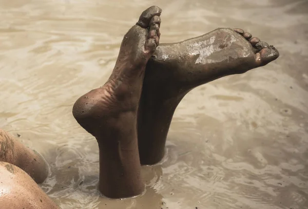 Dirty heels and feet. Legs butt in mud bath. Woman in the mud bath. Spa procedure and body care. Enjoying mud