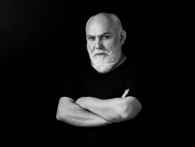 Sakallı, orta yaşlı, ciddi bir yüz ifadesi olan, yakın plan bir kafa ve omuz portresi olan adam.