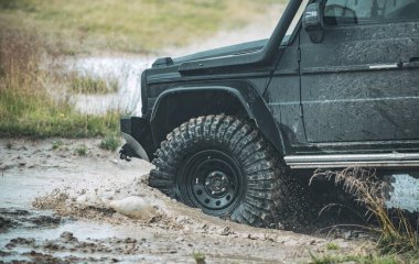 Kötü çakıllı yolda arazi aracı. Off-road yarışında çamur ve su sıçraması. Dağ yolunda off-road yolculuğu