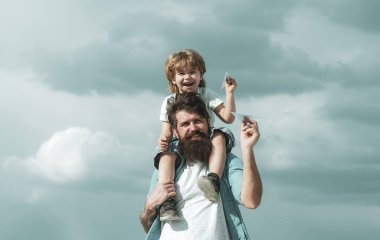 Nesil. Baba oğlunu parka geri götürüyor. Baba ve oğul birlikte kağıt uçak yapıyorlar. Mutlu bir babanın portresi. Oğlunu sırtında taşıyor ve yukarı bakıyor.