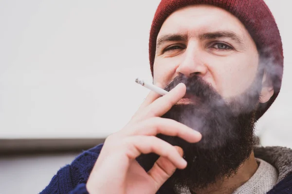 在城市外面吸烟的英俊男子的近照 有胡子的男人抽烟 — 图库照片