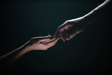 İki el uzanıyor. Şefkat ve şefkat siyah arka planda el ele tutuşur. Parmaklarınla romantik dokunuş, aşkım. Adem 'in el yapımı