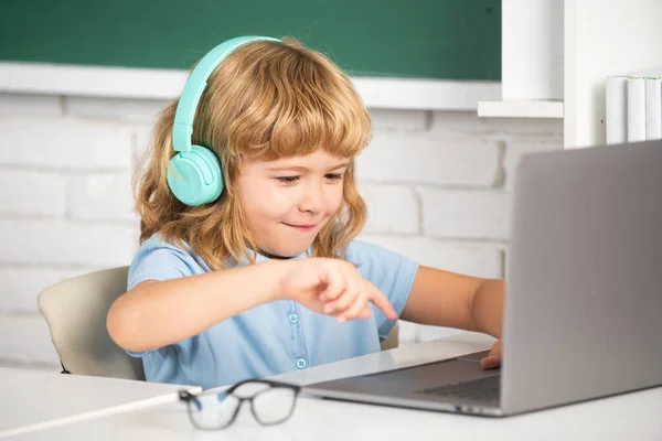 Slimme Jongen Een Koptelefoon Zit Achter Een Bureau Studeert Online — Stockfoto