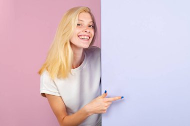 Kadın boş tahtayı işaret ediyor. Panonun arkasında duran ya da boş fotokopi alanı reklam panosu