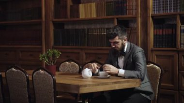 Okuyucu ve zeka kavramı. Erkekler kitaptan hoşlanır ve kahve ya da çay içer. Favori kitap konsepti. Sakallı adam en sevdiği kitabı okuyor.