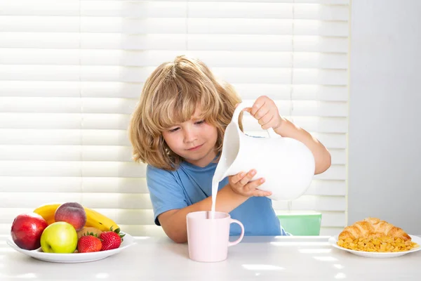 牛のミルクを注ぐ子供 学校の前に朝食を食べる子供 小さな十代の子供の肖像画自宅のキッチンで机に座っておいしい栄養価の高い朝食を持っています — ストック写真