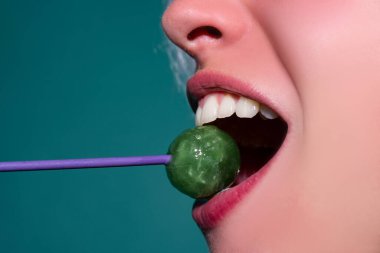 Close up lips with lollipop isolated, sexy blowjob, sensual mouth with lipstick eats sweets. Sexy design for women and girls. Beautiful lips